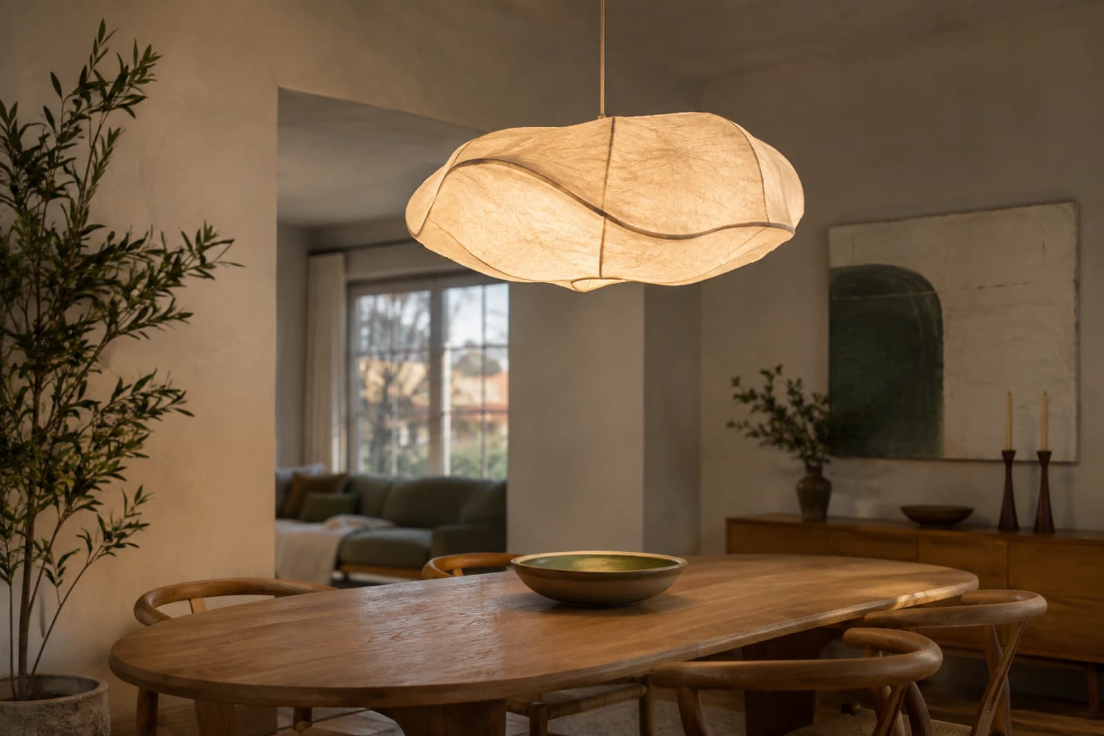 A sculptural pendant light over a dining table, acting as the focal point of the room